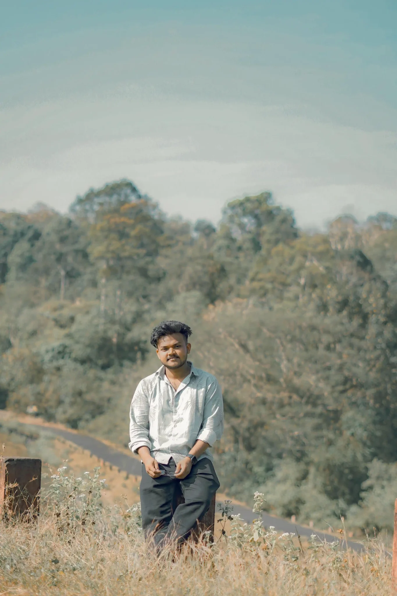 Freelance digital marketer in Malappuram wearing sunglasses, standing casually in front of a fence with an aesthetic vibe